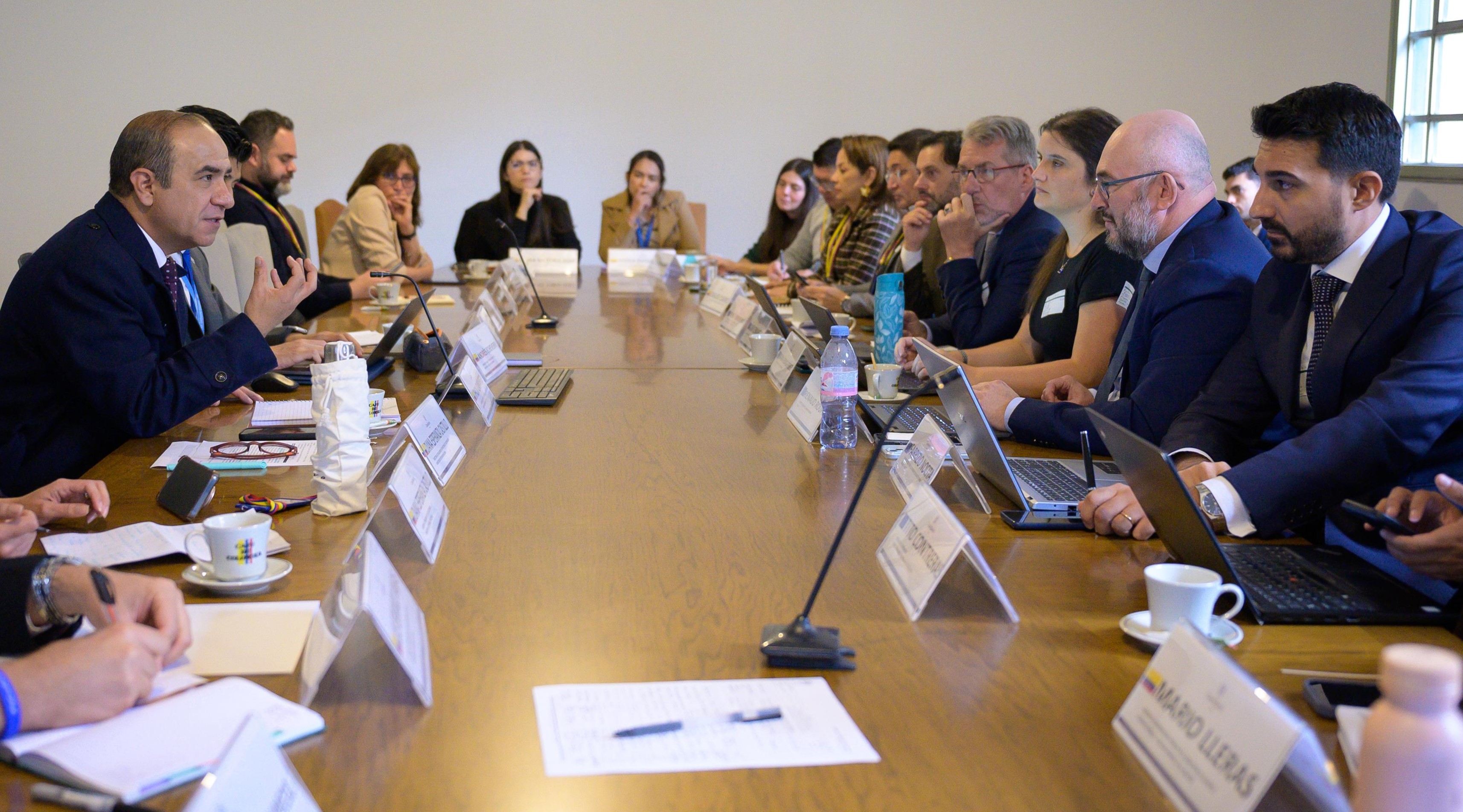 Foto del encuentro de funcionarios del Ministerio de Relaciones Exteriores y la delegación técnica del Programa de Asistencia contra el Crimen Organizado Transnacional (PAcCTO 2.0), en una mesa de una sala de juntas.